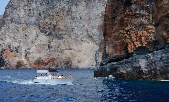 Barco junto às falésias da costa algarvia