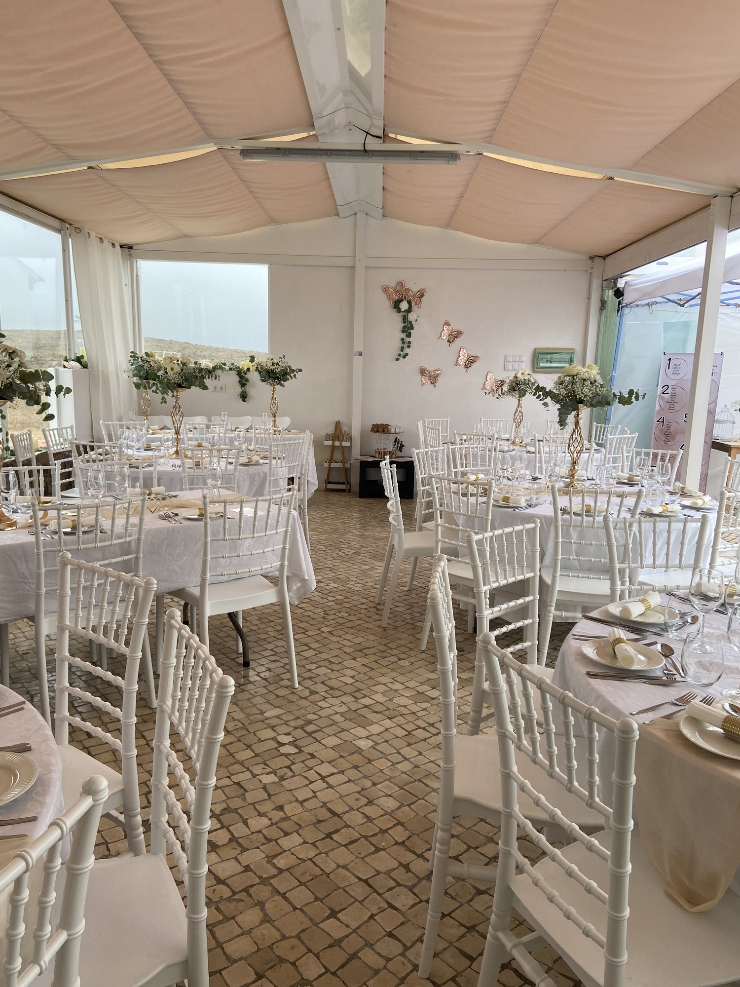 Sala de eventos montada com mesas e cadeiras para uma celebração
